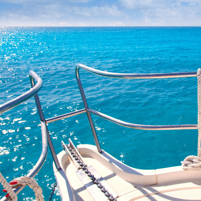 Anchor boat y tropical idyllic tropical turquoise beach under blue sky and clouds